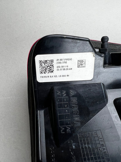 "Close-up of the manufacturer label on a RAM 1500 RH tail light, showing part number 55112992AD and Magna logo. Genuine Mopar part."